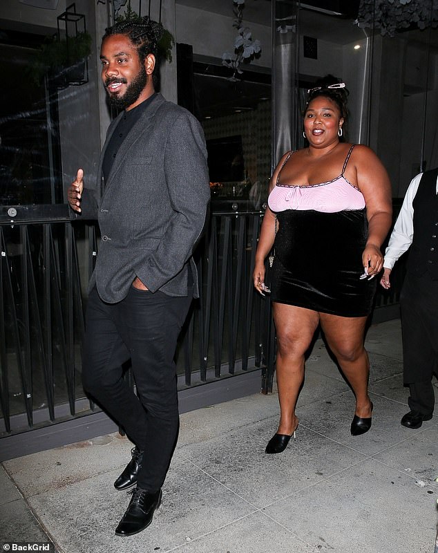 Lizzo shows off her curves in a short dress as she enjoys a night out with mystery man