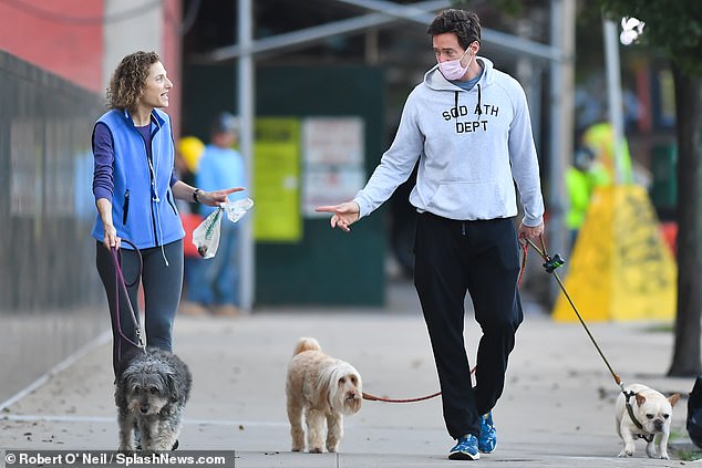 Hugh Jackman walks his dogs while chatting with a friend in New York City 