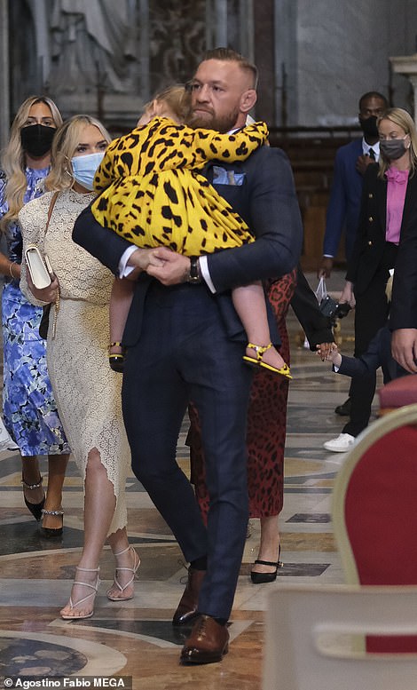 Conor McGregor carries his daughter during the christening of his son Rían at The Vatican in Rome