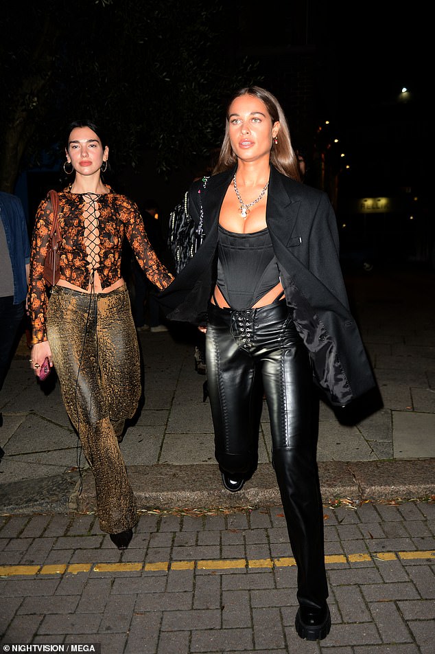Dua Lipa flaunts her cleavage in a racy tie-up top as she enjoys a dinner date