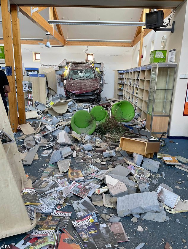 Elderly couple are left trapped in a LIBRARY after their car smashed through its wall 