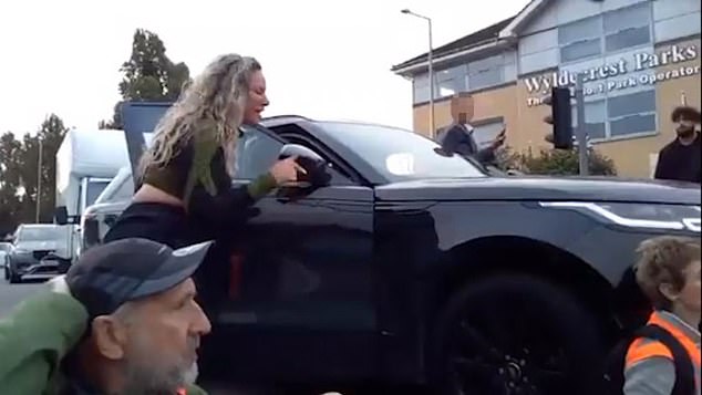 Moment furious mother RAMS Insulate Britain activists with her 4×4 and pushes them along the road