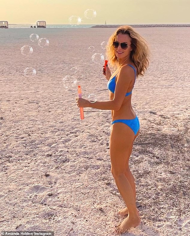 Amanda Holden, 50, flaunts her incredible figure in a tiny blue bikini during idyllic family trip