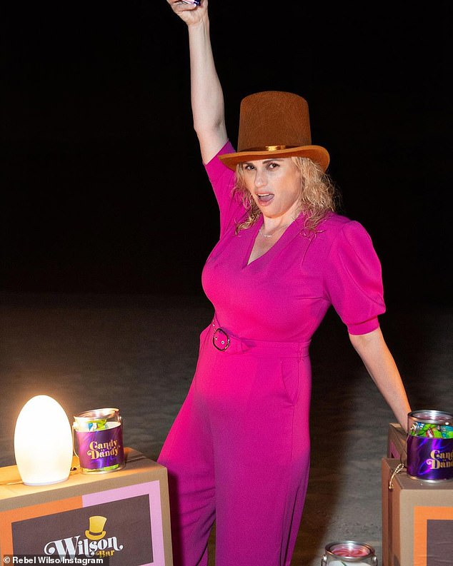 Rebel Wilson shows off her slimmed-down figure and trim waist in a fuchsia jumpsuit