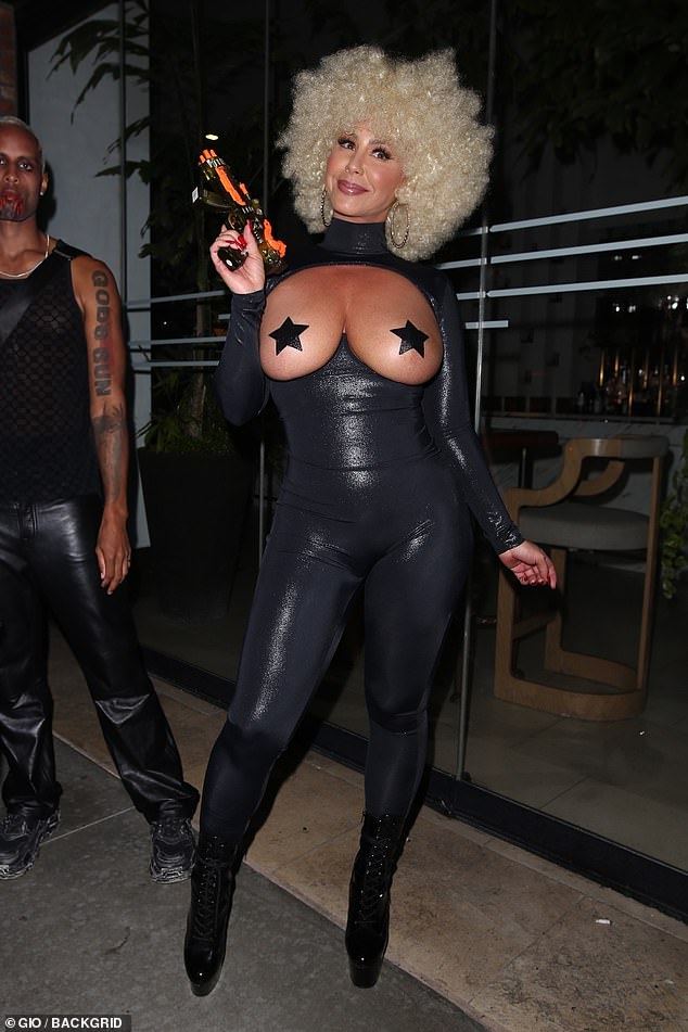 Amber Rose arrives TOPLESS in a very risqué catsuit for Halloween bash 