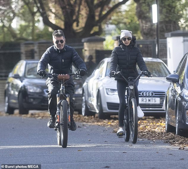 Simon Cowell goes for a morning bike ride with partner Lauren Silverman
