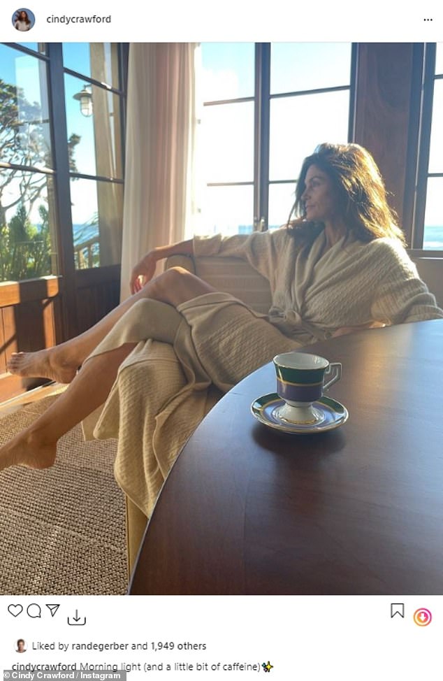 Cindy Crawford captures the perfect morning light as she basks in the sunrise wearing a robe