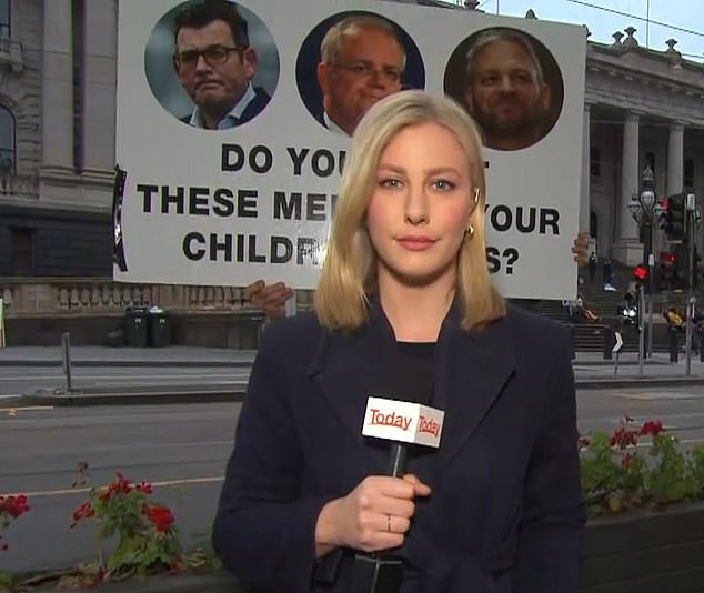 Today show reporter Izabella Staskowski glares in Melbourne as Dan Andrews protester holds sign