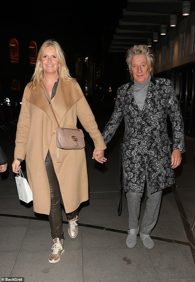 Rod Stewart and Penny Lancaster hold hands as they arrive at The One Show alongside Rosamund Pike