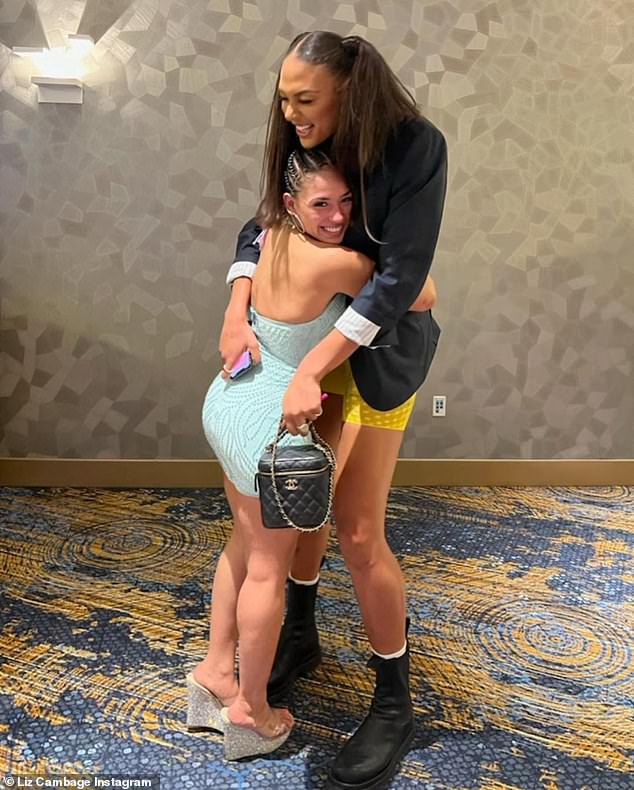 Liz Cambage towers over MMA fighter Valerie Loureda as the two athletes share a friendly hug 