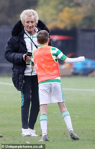 Rod Stewart wears a tracksuit and winter coat as he wraps up to watch son Aiden play football