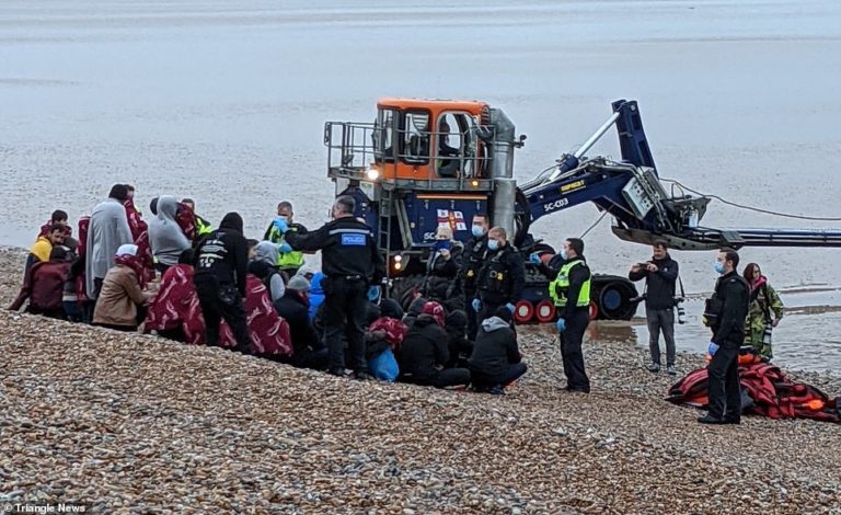 Mother clutches baby to chest as she scrambles up Kent beach after 200 migrants make Channel dash