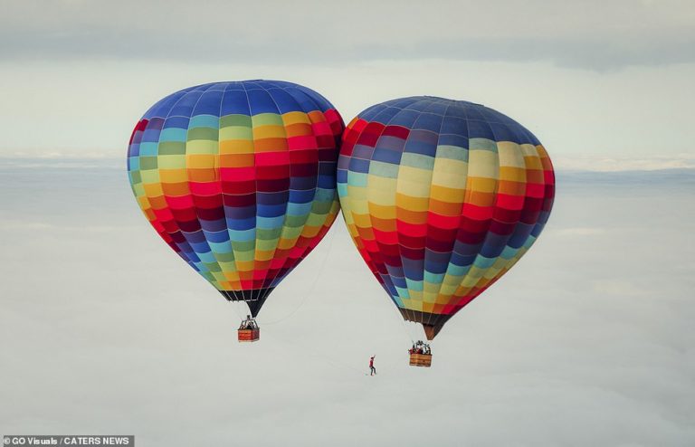 Daredevil breaks slackline world record walking between two hot air balloons at 6,100ft