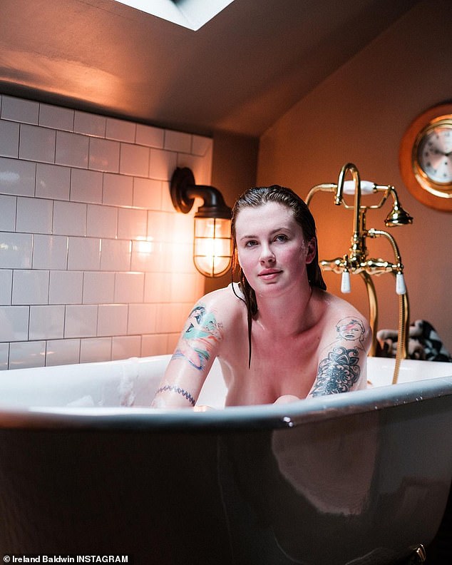 Ireland Baldwin embraces natural beauty while posing nude in a bubble bath at a Nashville hotel