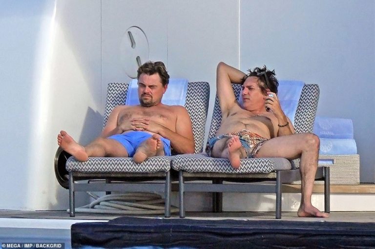 Leonardo DiCaprio tops up tan from the back of a massive yacht with best buddy Lukas Haas