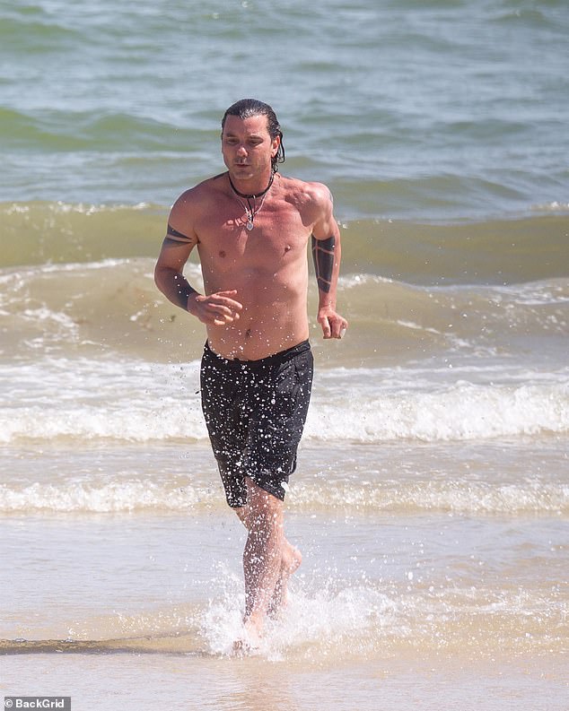 Gavin Rossdale, 56, works out at the beach before dining next to a blonde beauty at a café
