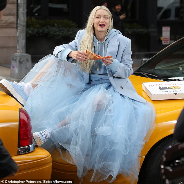 Gigi Hadid showcases her legs in sheer blue skirt as she indulges in a slice of pizza during shoot 