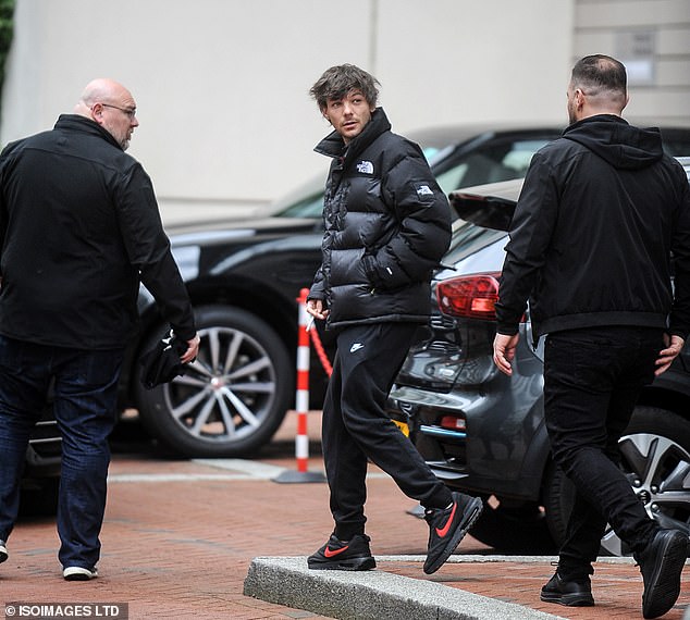 Louis Tomlinson cuts a handsome figure as he leaves his hotel ahead of his concert in Manchester