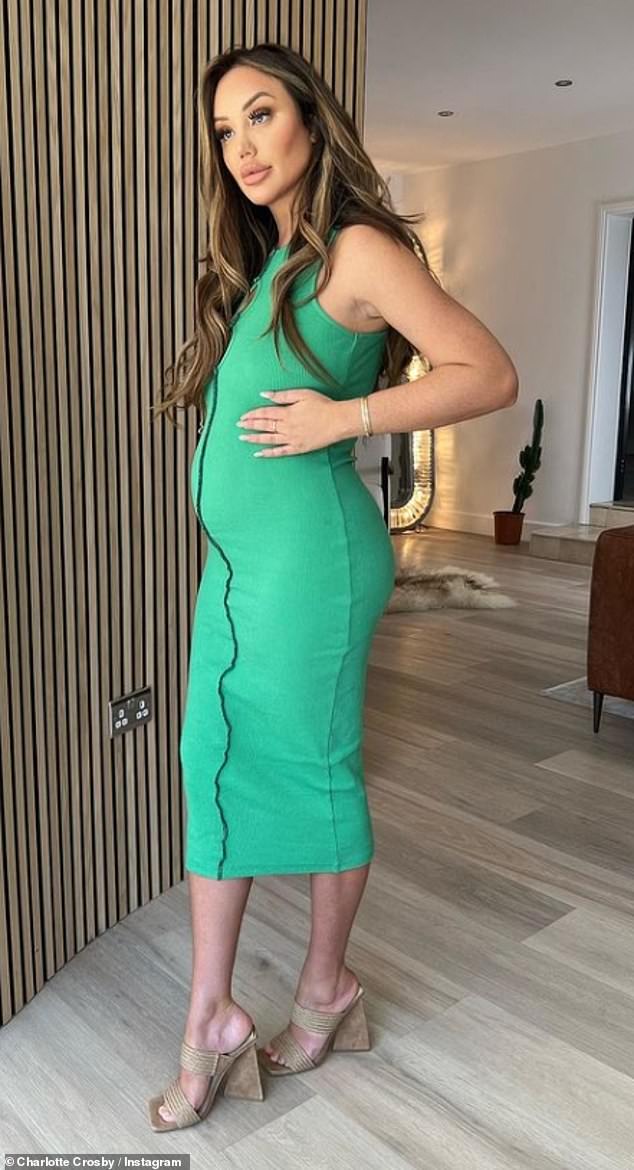 Pregnant Charlotte Crosby cradles her growing tummy in a formfitting midi dress