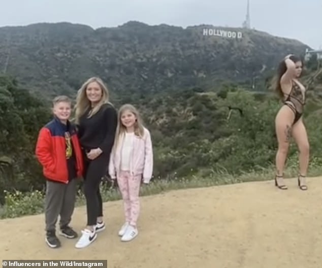 Awkward moment a family photo is ruined by nearly-nude woman posing next to them