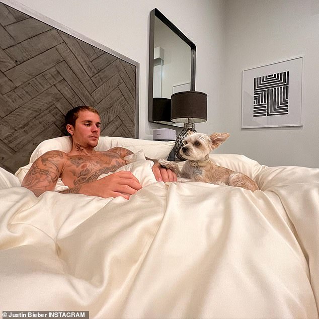 Justin Bieber relaxes shirtless in bed with his beloved dog Oscar