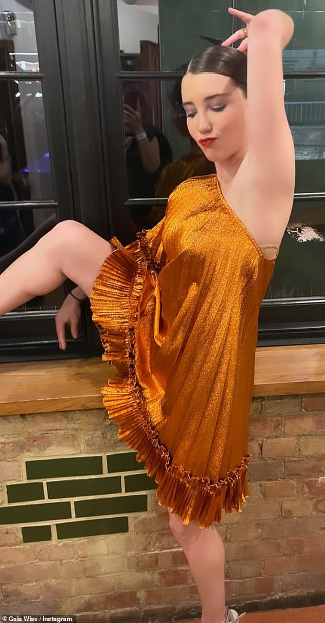 Emma Thompson’s daughter Gaia Wise, 22, shows off her flexibility in striking amber gown for snap