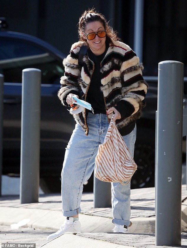 Celeste Barber feels the chill as she rugs up in a cosy jacket and jeans